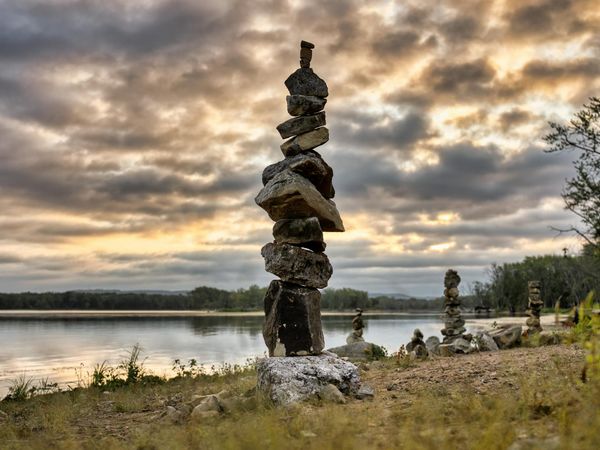 A calm, serene natural landscape with stacked stones, representing balance and mindfulness philosophy.